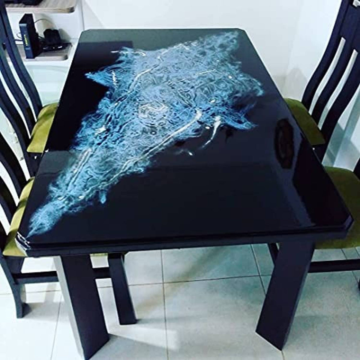 Black countertop epoxy with bright blue marbling effect, glossy cured finish