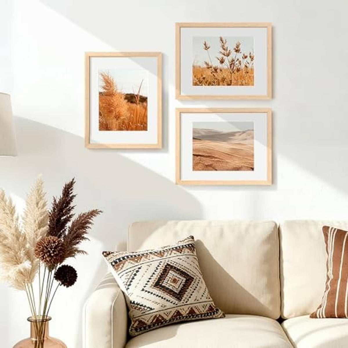Three natural wood picture frames mounted on a wall in a home setting