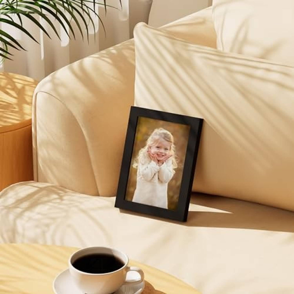 Black 5x7 picture frame with clear shatterproof plexiglass, displayed on a sofa table.
