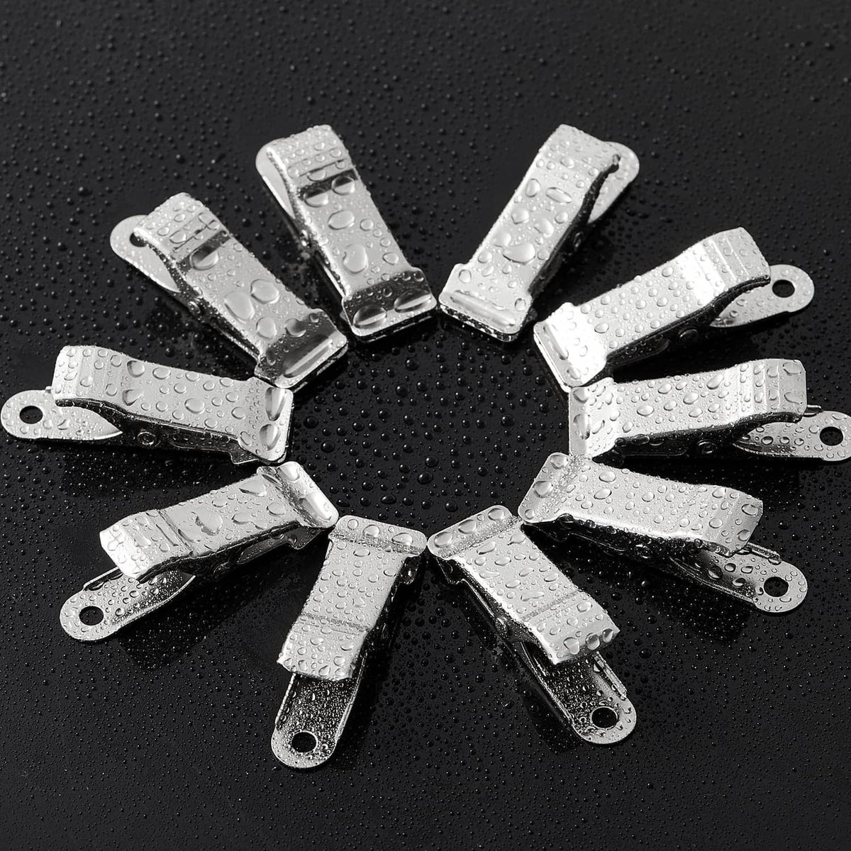 Silver metal spring clamps arranged in a circle, shown with water droplets