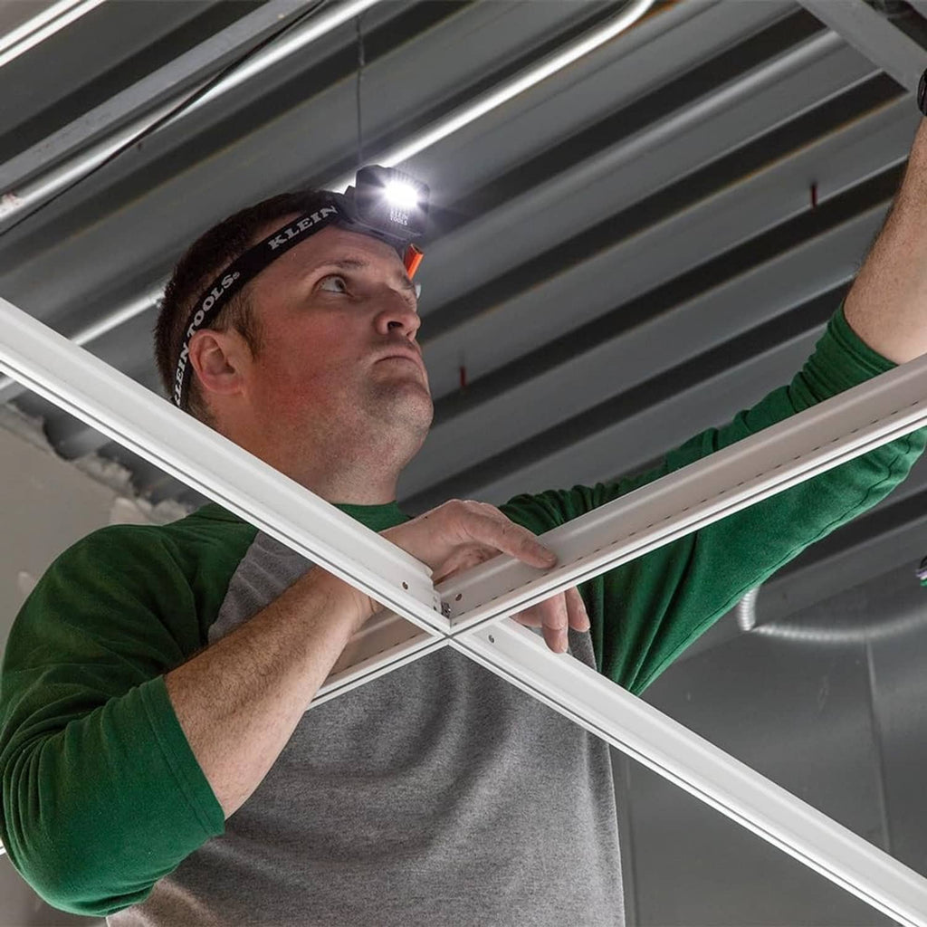 Worker wearing rechargeable LED headlamp on a black adjustable headband