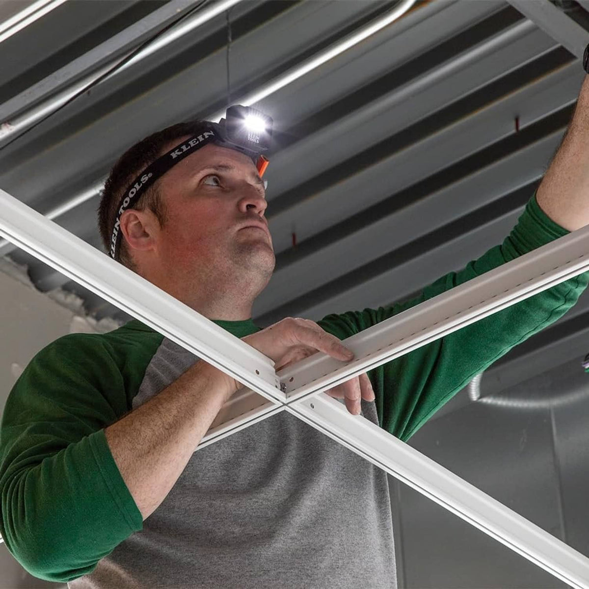 Worker wearing rechargeable LED headlamp on a black adjustable headband