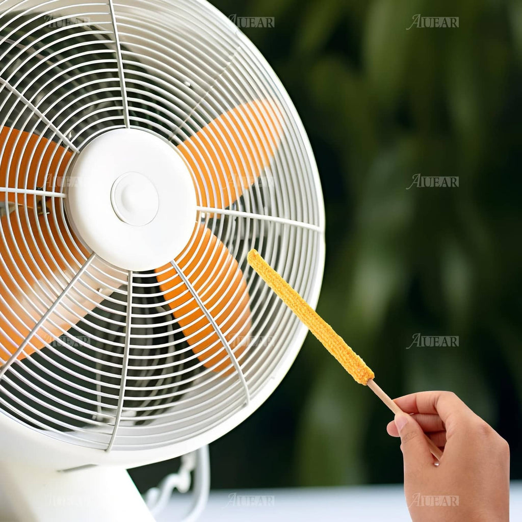 Orange microfiber duster stick on a fan grille, with wooden handle