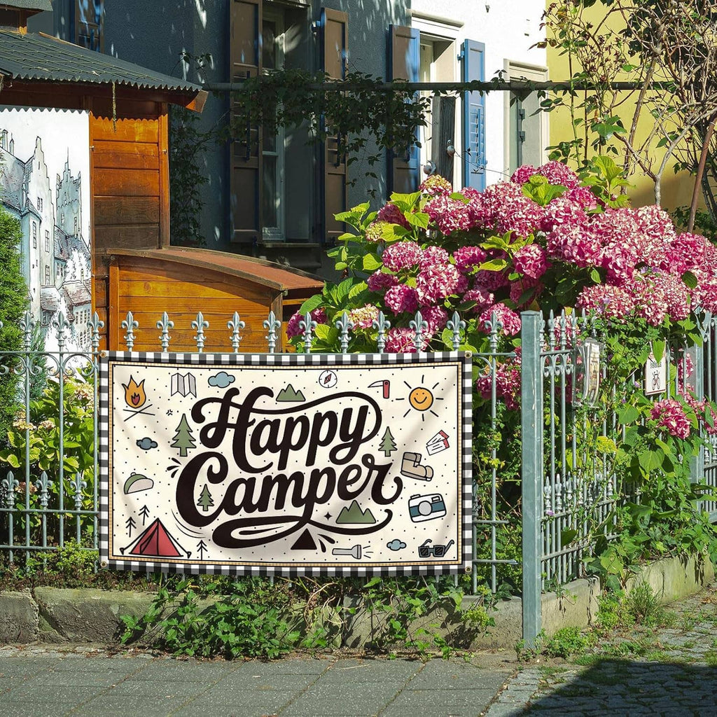 “Happy Camper” camping banner flag with illustrated icons and brass grommets hanging outdoors