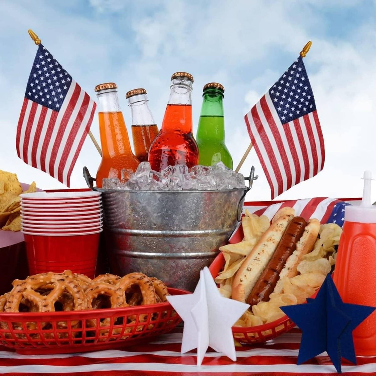 Two small US flags on wooden sticks standing among party items