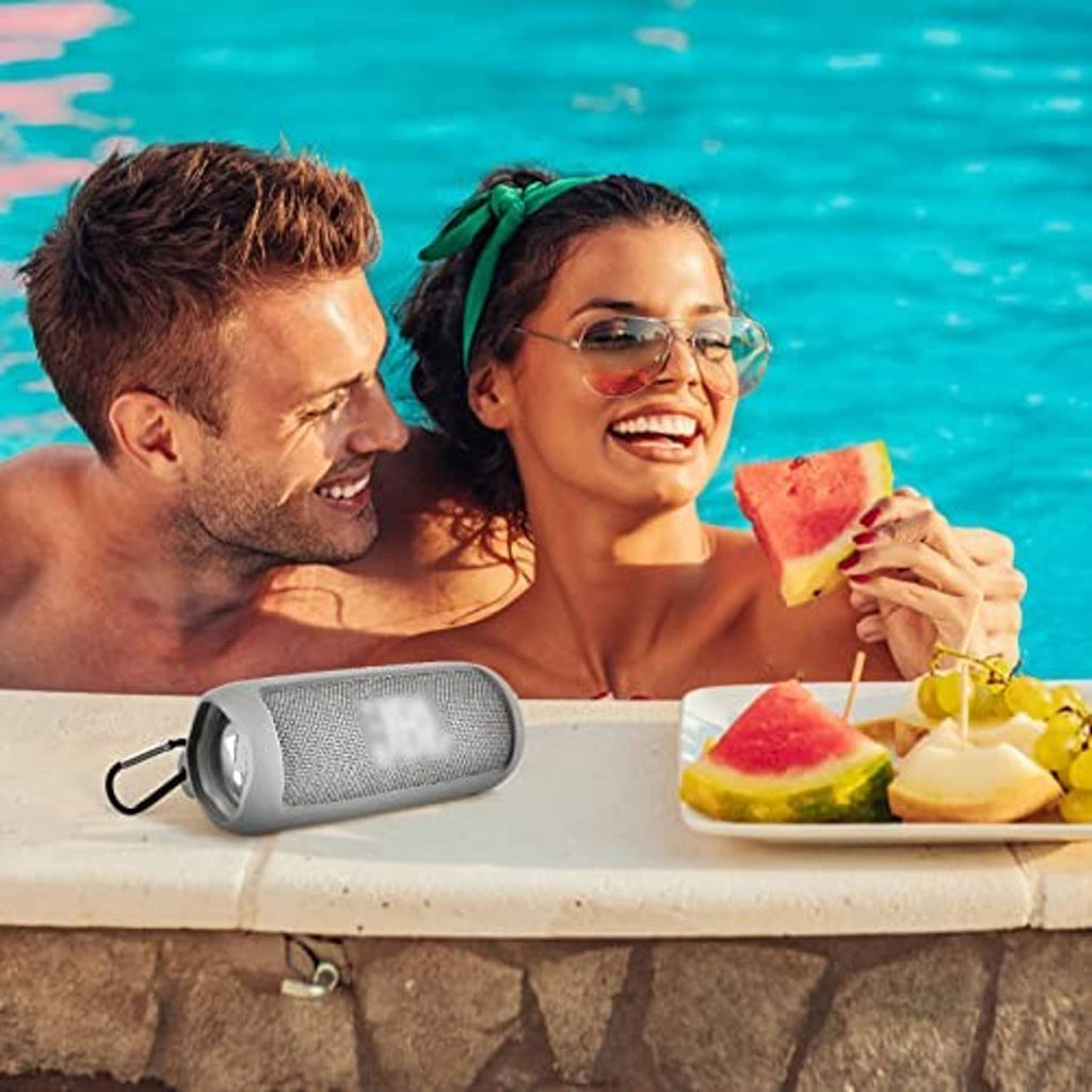 Gray silicone-cased portable Bluetooth speaker by the pool with shoulder strap attached