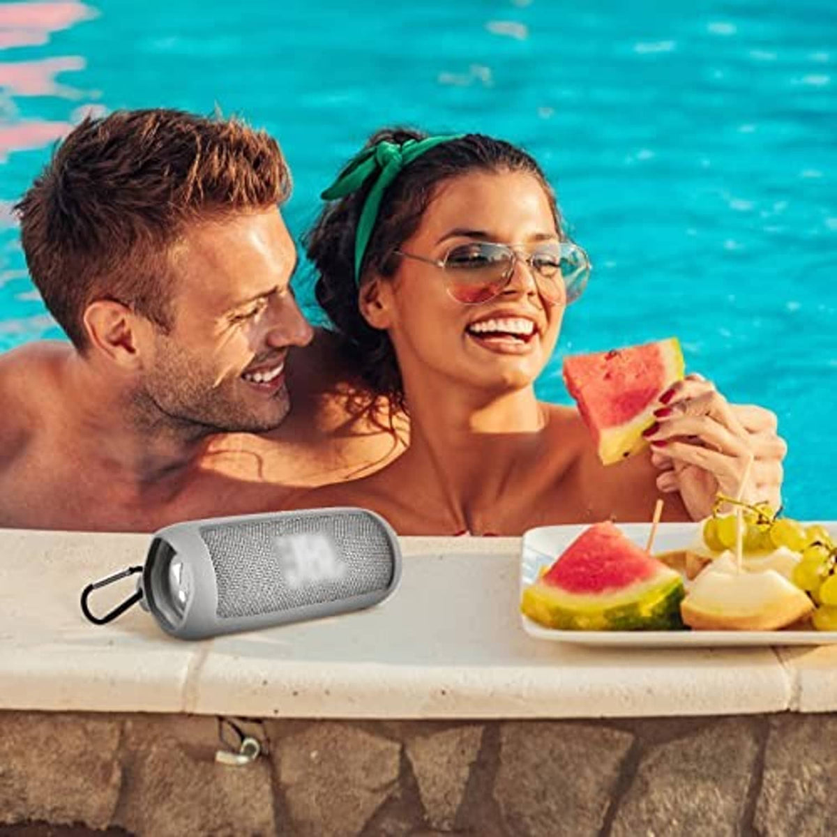 Gray silicone-cased portable Bluetooth speaker by the pool with shoulder strap attached
