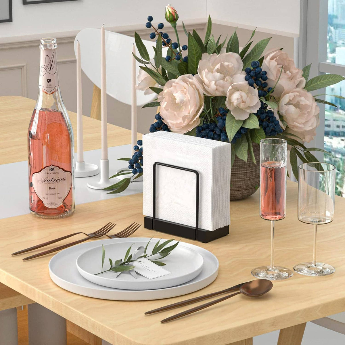 Table napkin dispenser with black stand holding white napkins, placed on tabletop.
