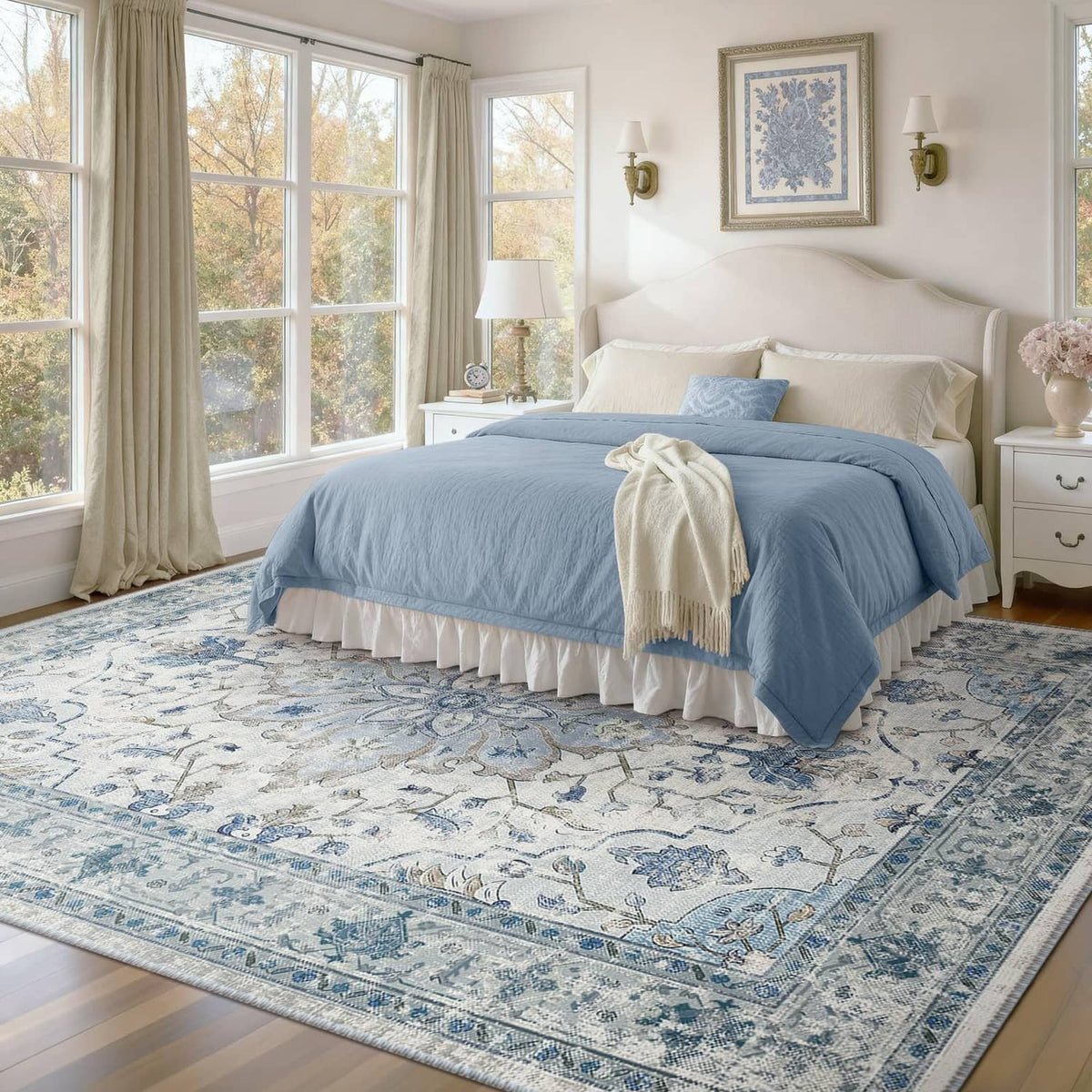 Large rectangular area rug with blue and white ornate pattern beneath a bed