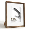 Walnut wood 8x10 picture frame with white mat and glass, shown on a standing easel