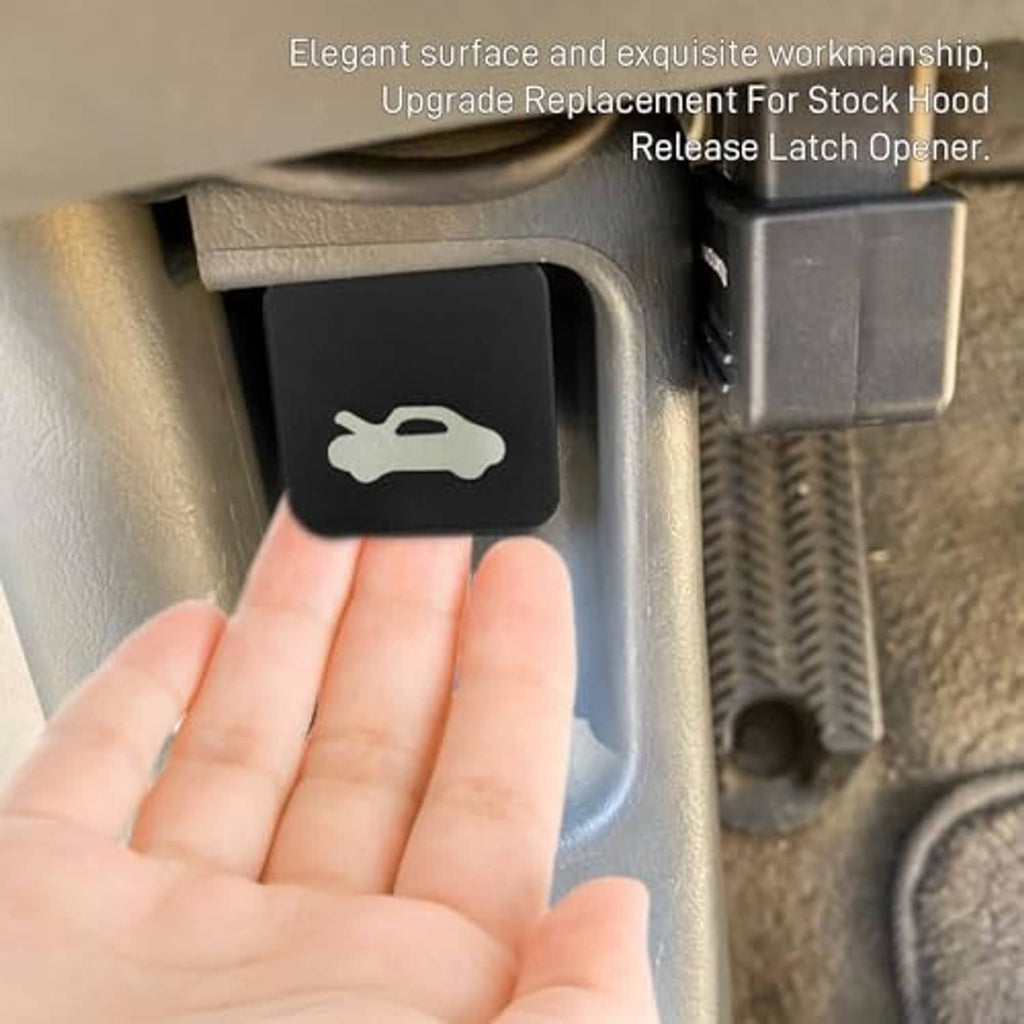 Black hood release latch handle in car interior, hand pressing the button