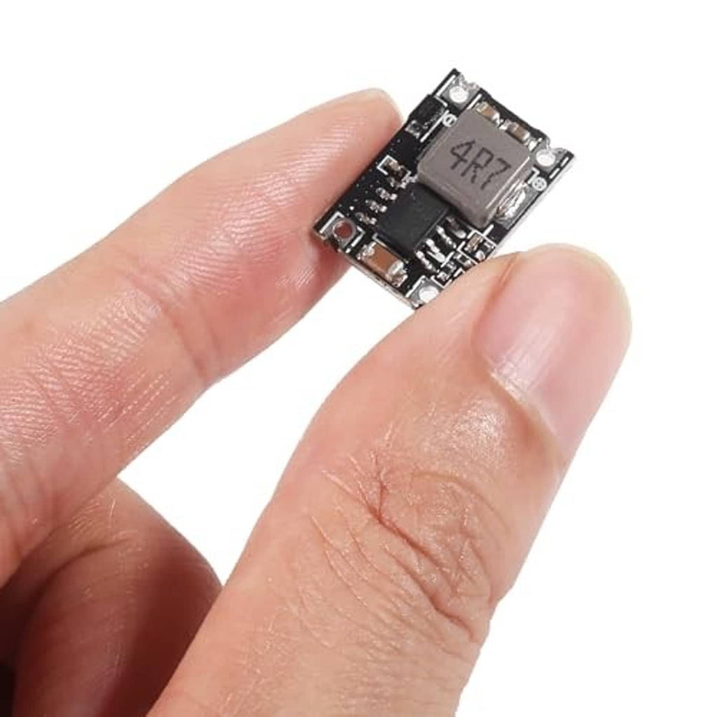 Small DC-DC power supply module held in hand, showing regulator IC on PCB
