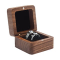 Square solid wood ring box with hinged lid, open to two black velvet ring slots