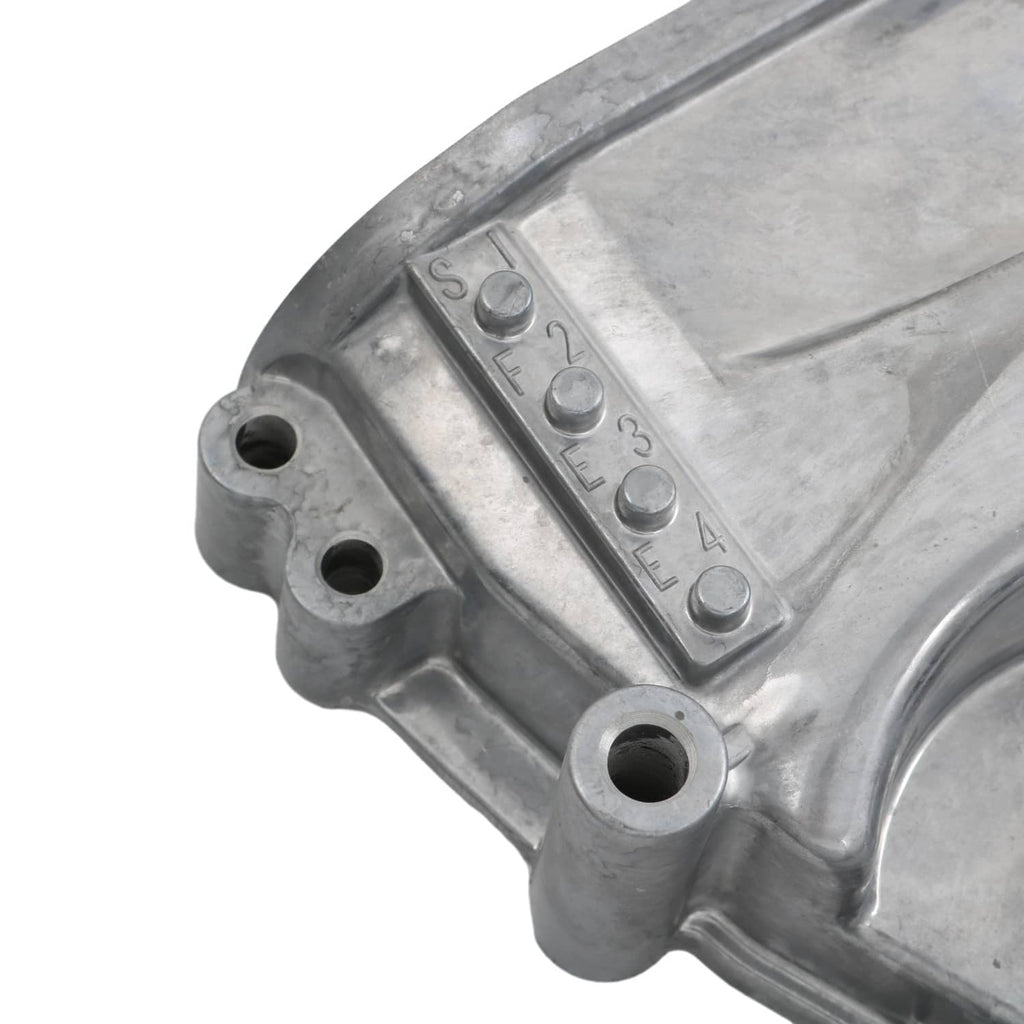 Timing cover oil pump housing close-up with stamped markings on silver metal