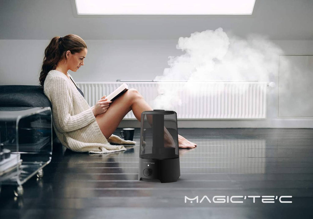 Black cool mist humidifier producing mist near a seated person