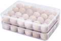 Clear plastic egg holder with lid, filled with light-colored eggs