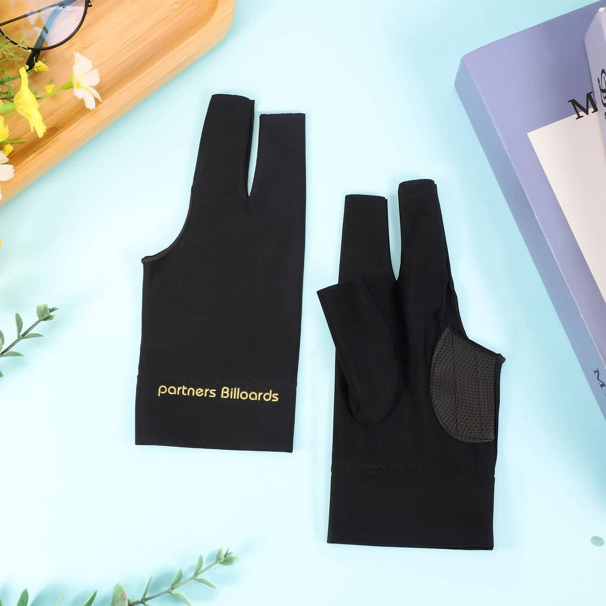 Black fingerless billiards gloves, two pairs laid flat with textured anti-slip palm