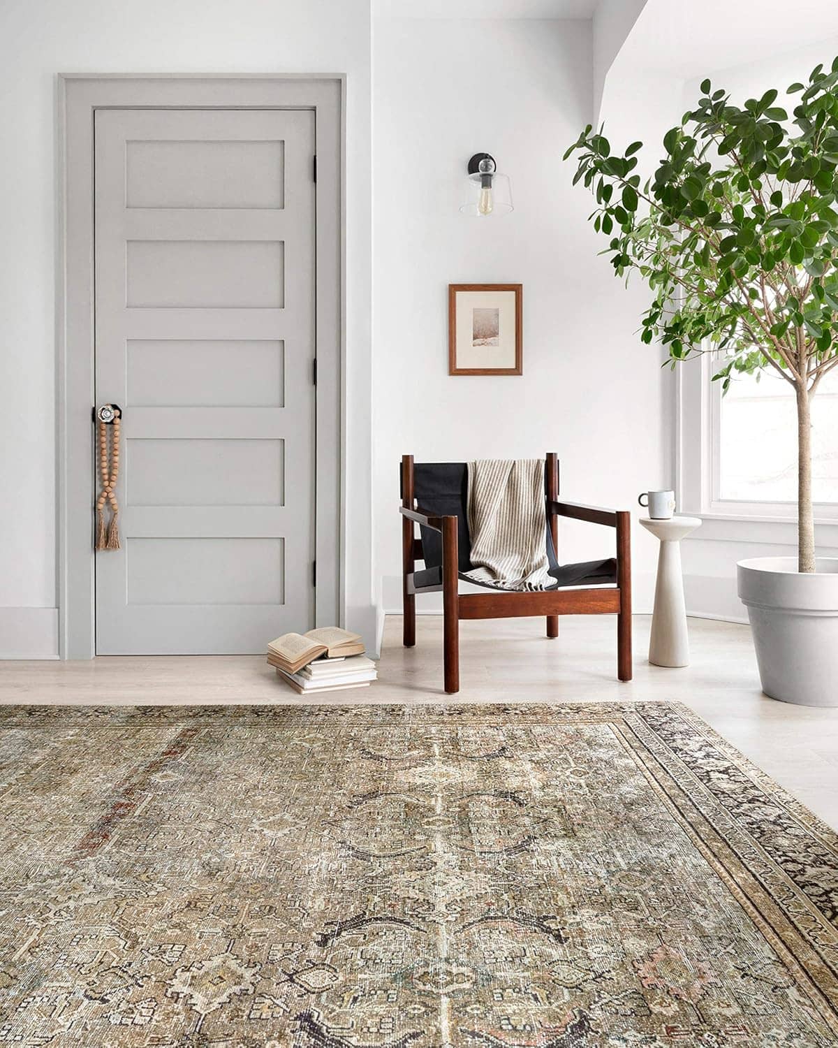 Distressed area rug with traditional motif pattern in muted olive, cream, and dark charcoal
