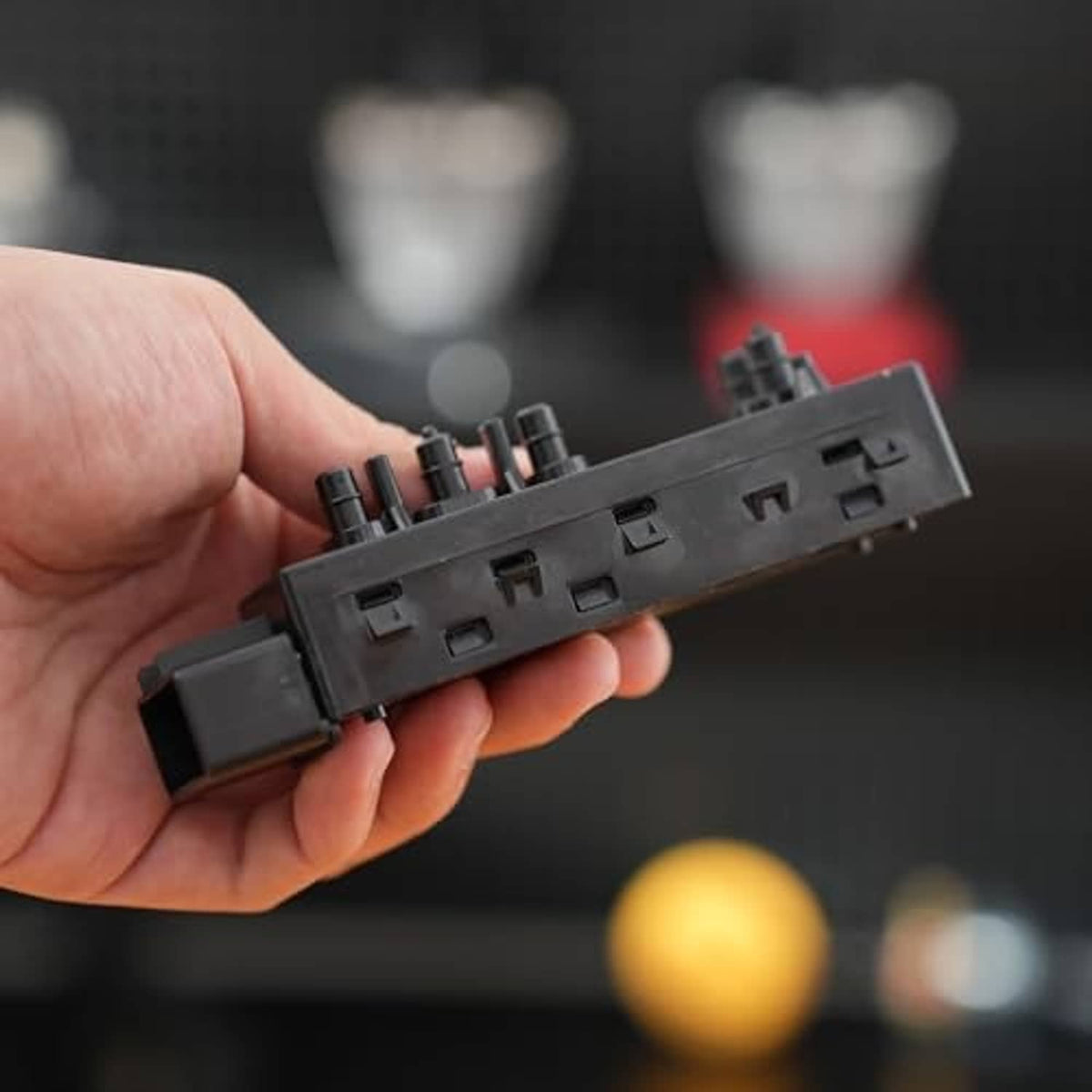 Power seat switch module back side with wiring ports and plastic mounting tabs