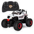 RC monster truck with white dalmatian-style body and black tires, with black remote
