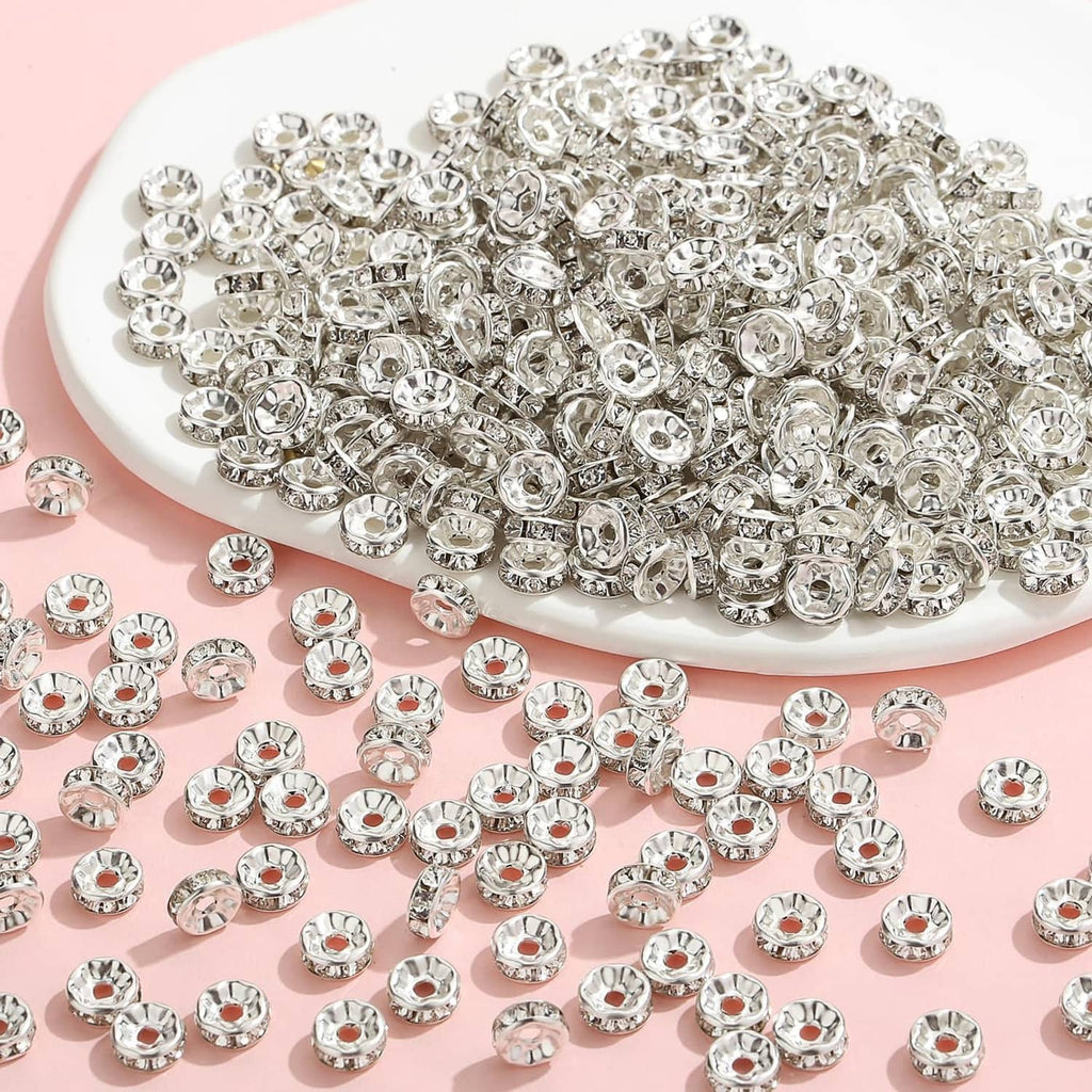 Pile of silver rhinestone rondelle spacer beads with faceted crystal centers