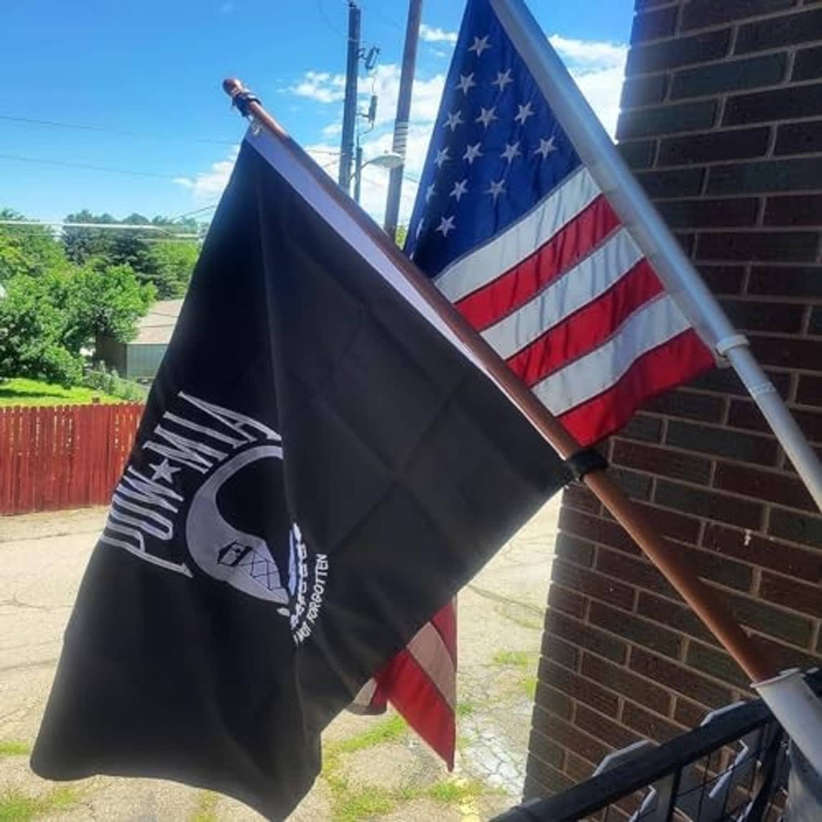 Embroidered POW-MIA flag with POW-MIA emblem waving on an outdoor pole