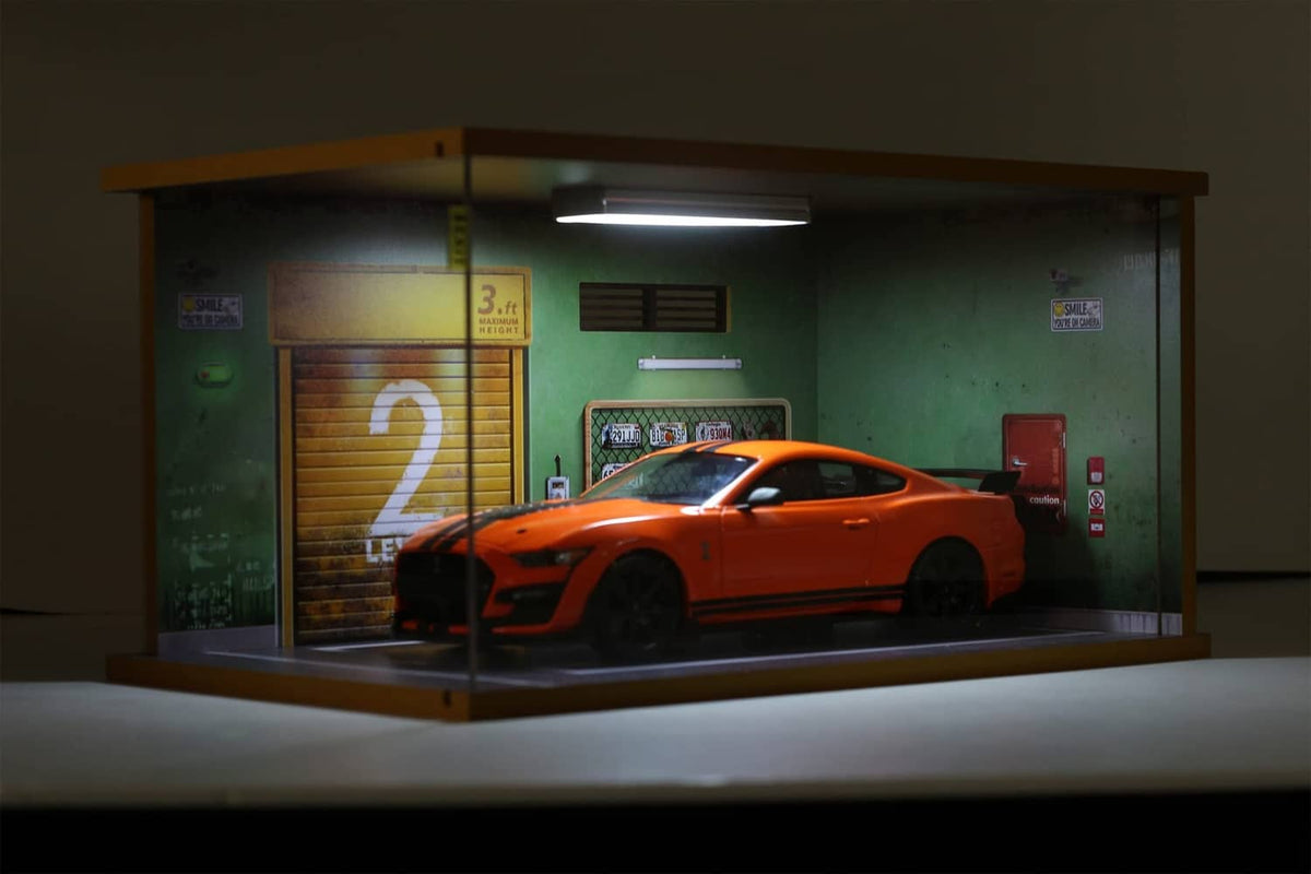 1:18 model car garage display case with orange car inside behind clear acrylic