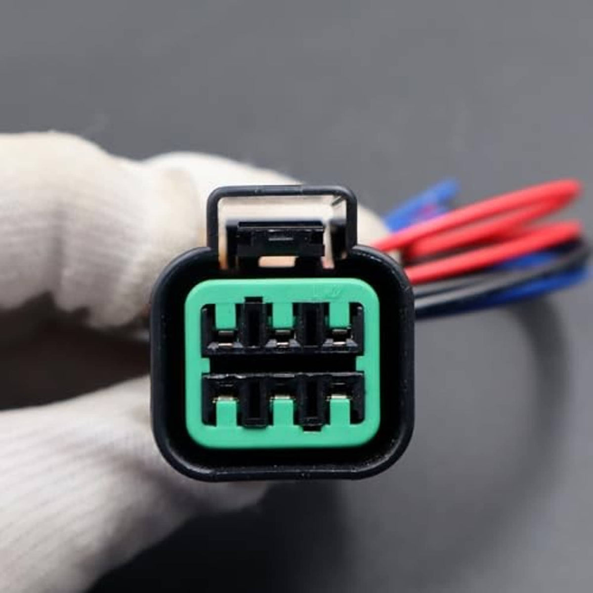 6-pin headlight connector face with green terminals and red/blue wires