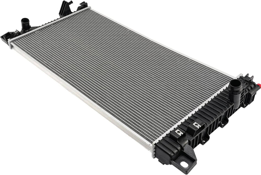 Vehicle radiator angled view with silver cooling fins and black plastic end tanks