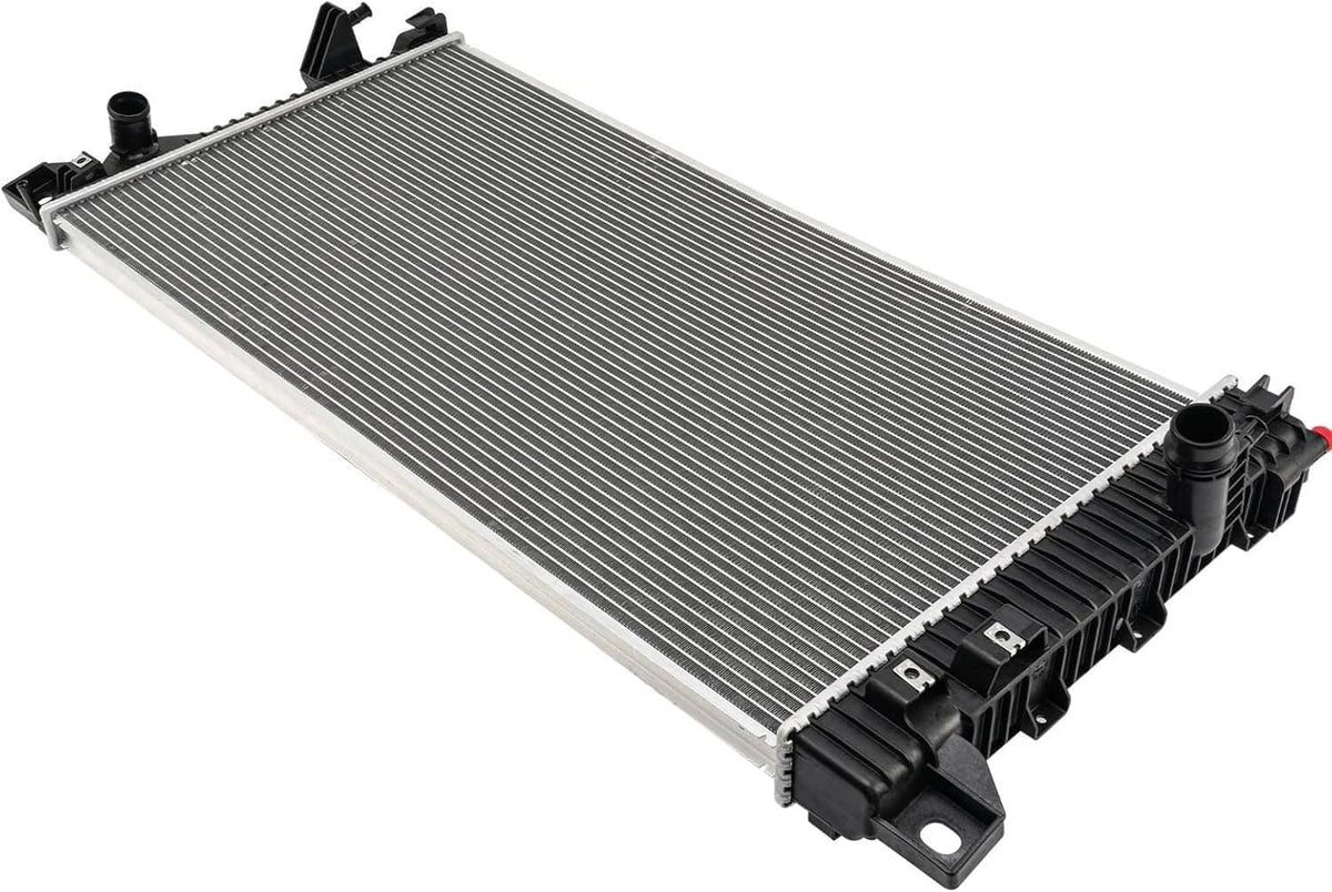 Vehicle radiator angled view with silver cooling fins and black plastic end tanks