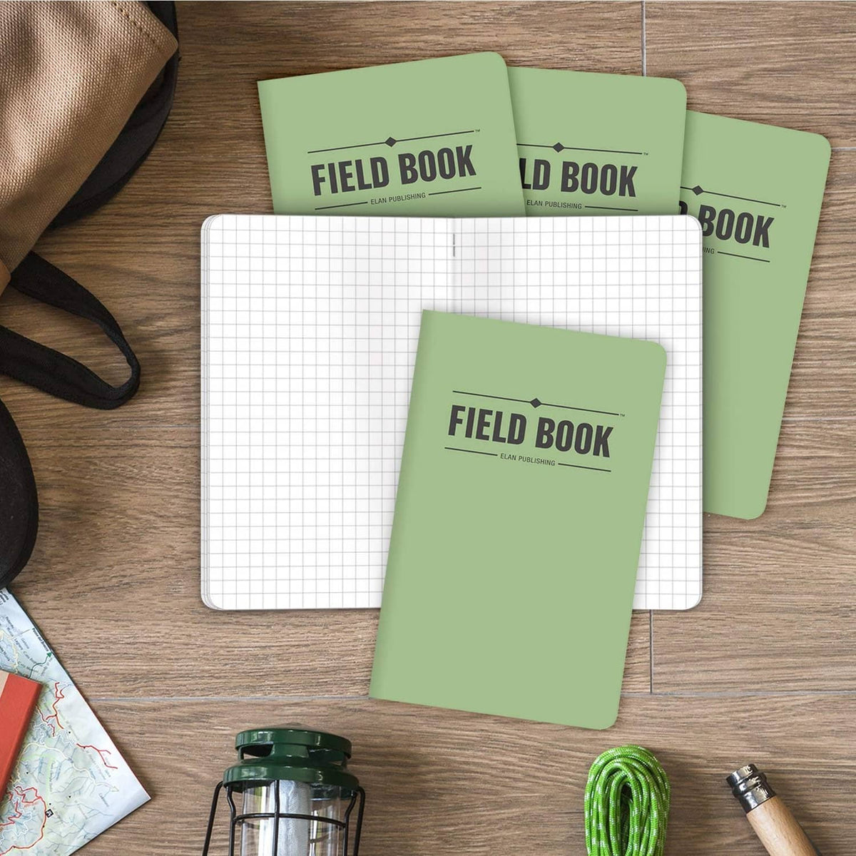 Set of five green Field Book notebooks stacked, with graph paper pages visible
