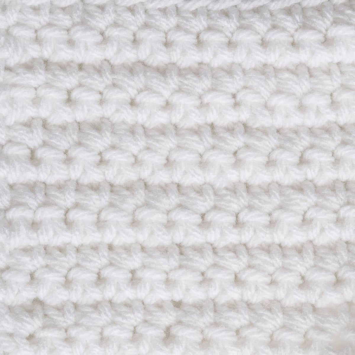 White crocheted fabric with raised loop stitches, close-up