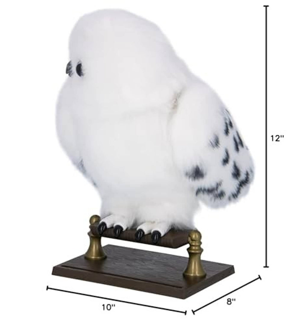 White plush owl with black speckles on dark wooden base with gold posts