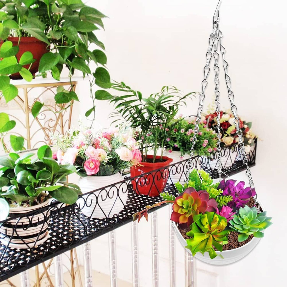 White hanging planter pot with metal chain holding flowers and succulents