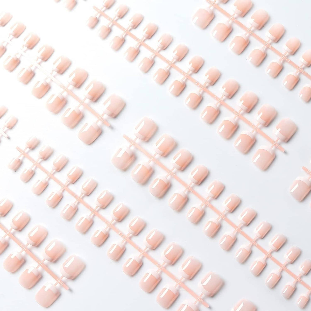 Assorted pink short press-on nails with white French tips, glossy top coat