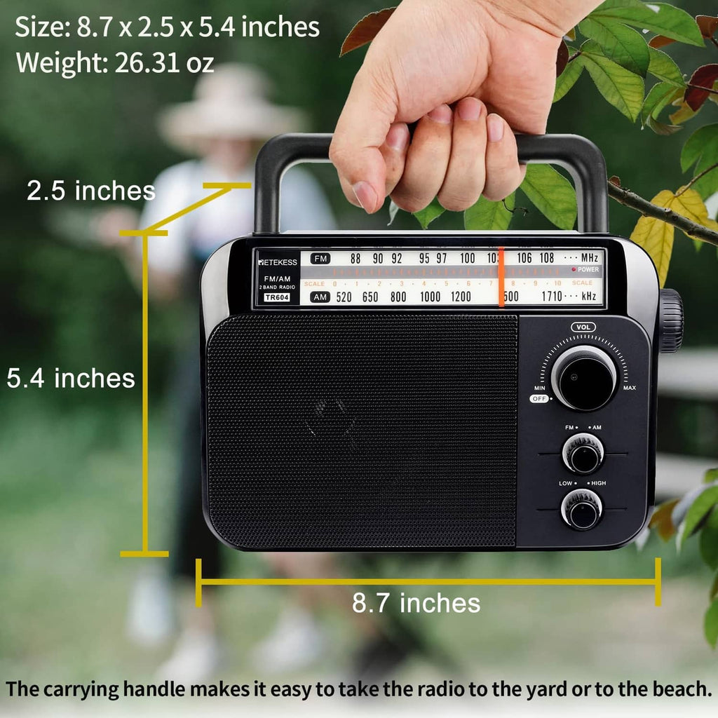 Hand holding a portable AM/FM radio by the top carrying handle