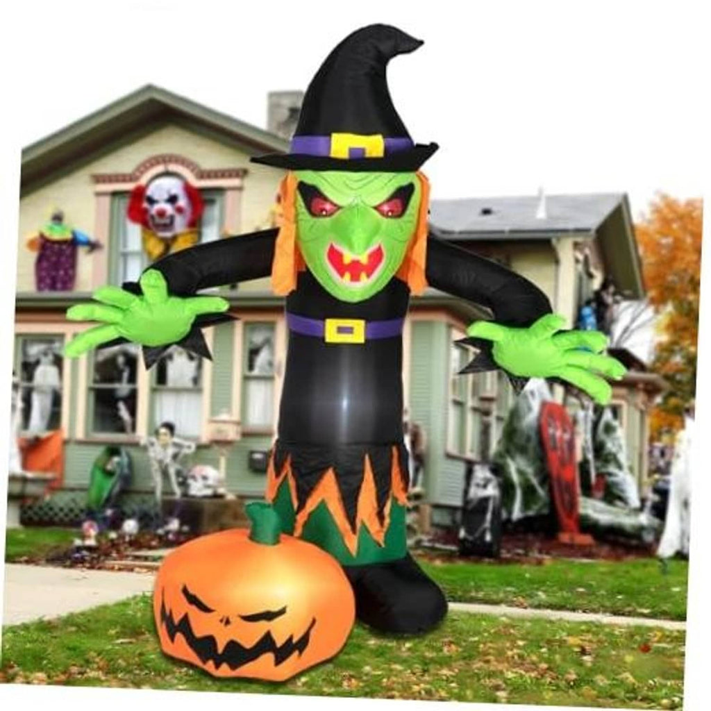 Inflatable Halloween witch figure with green face, black hat, and jack-o'-lantern base