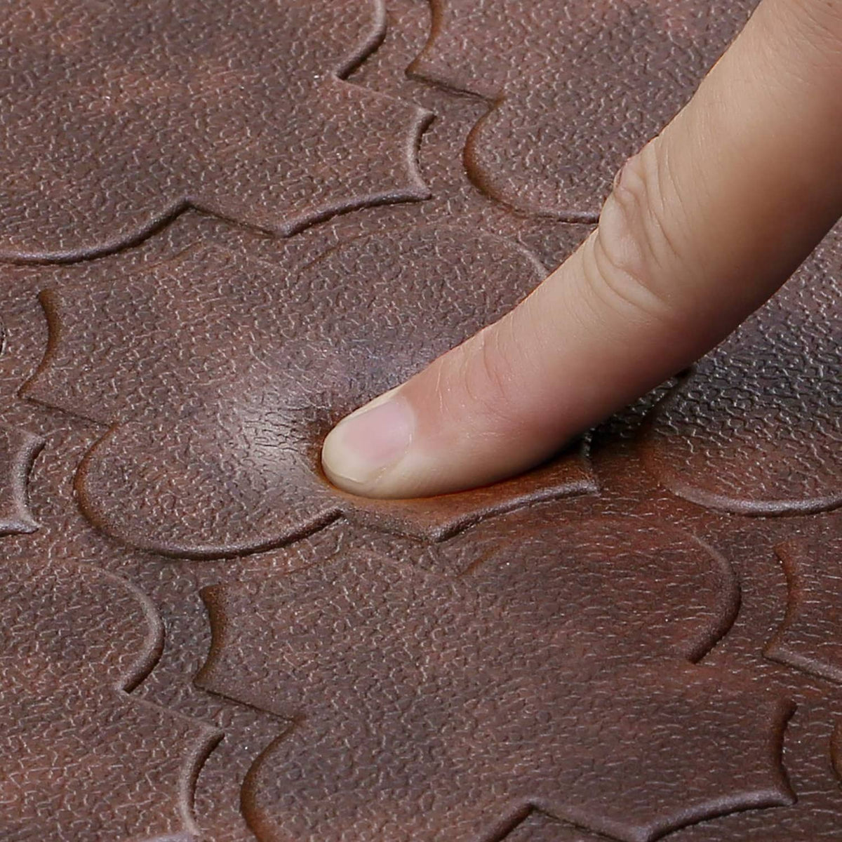 Close-up of brown kitchen mat with embossed clover pattern and grippy texture
