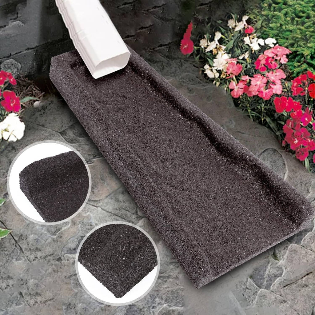 Brown rubber downspout splash block on stone pavers, textured surface visible