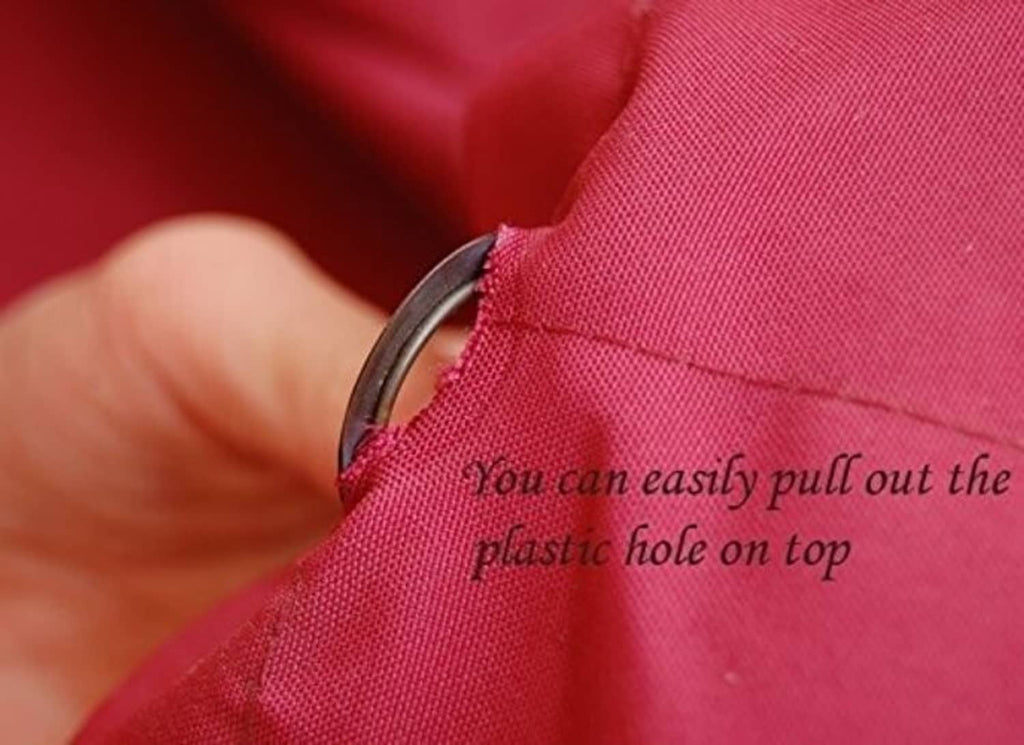Close-up of red umbrella canopy fabric near a grommet hole, showing pull-out piece