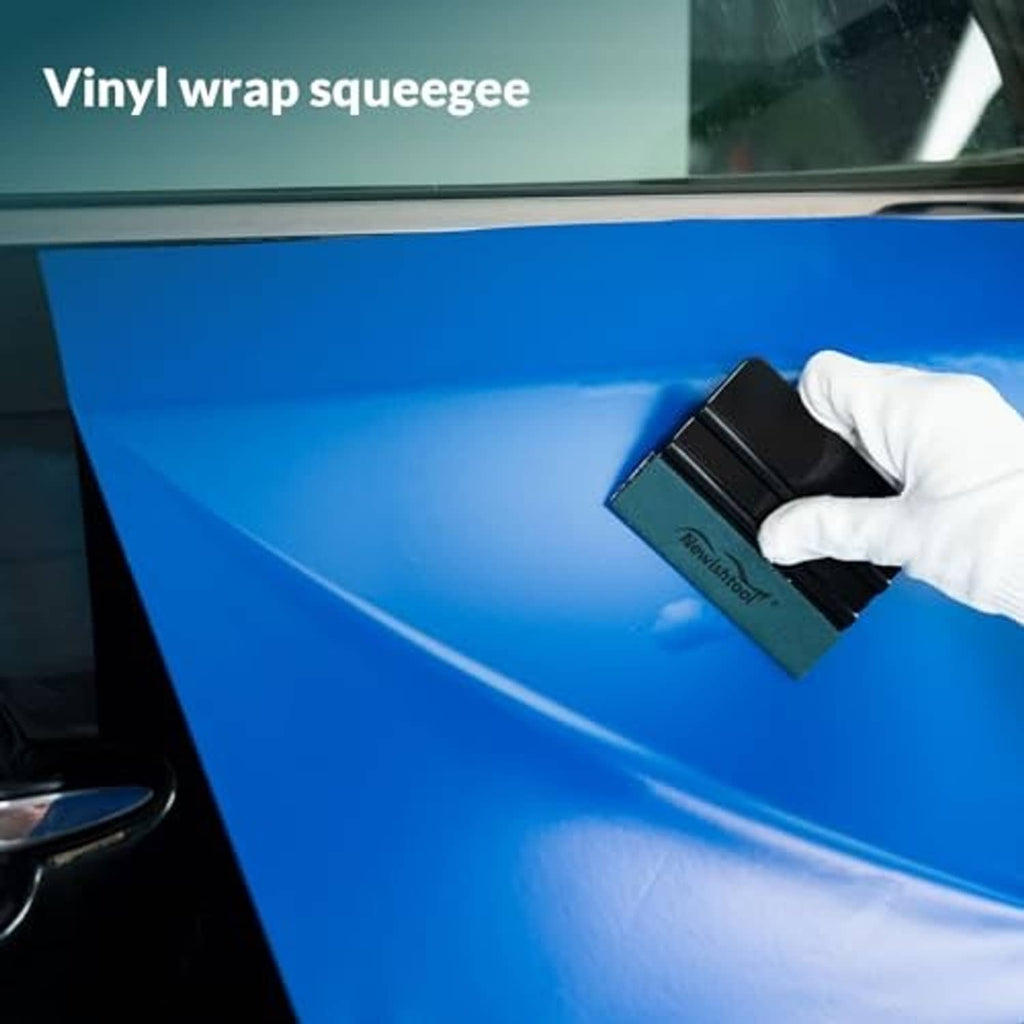 Vinyl wrap squeegee with felt pad, black tool smoothing wrap on vehicle surface