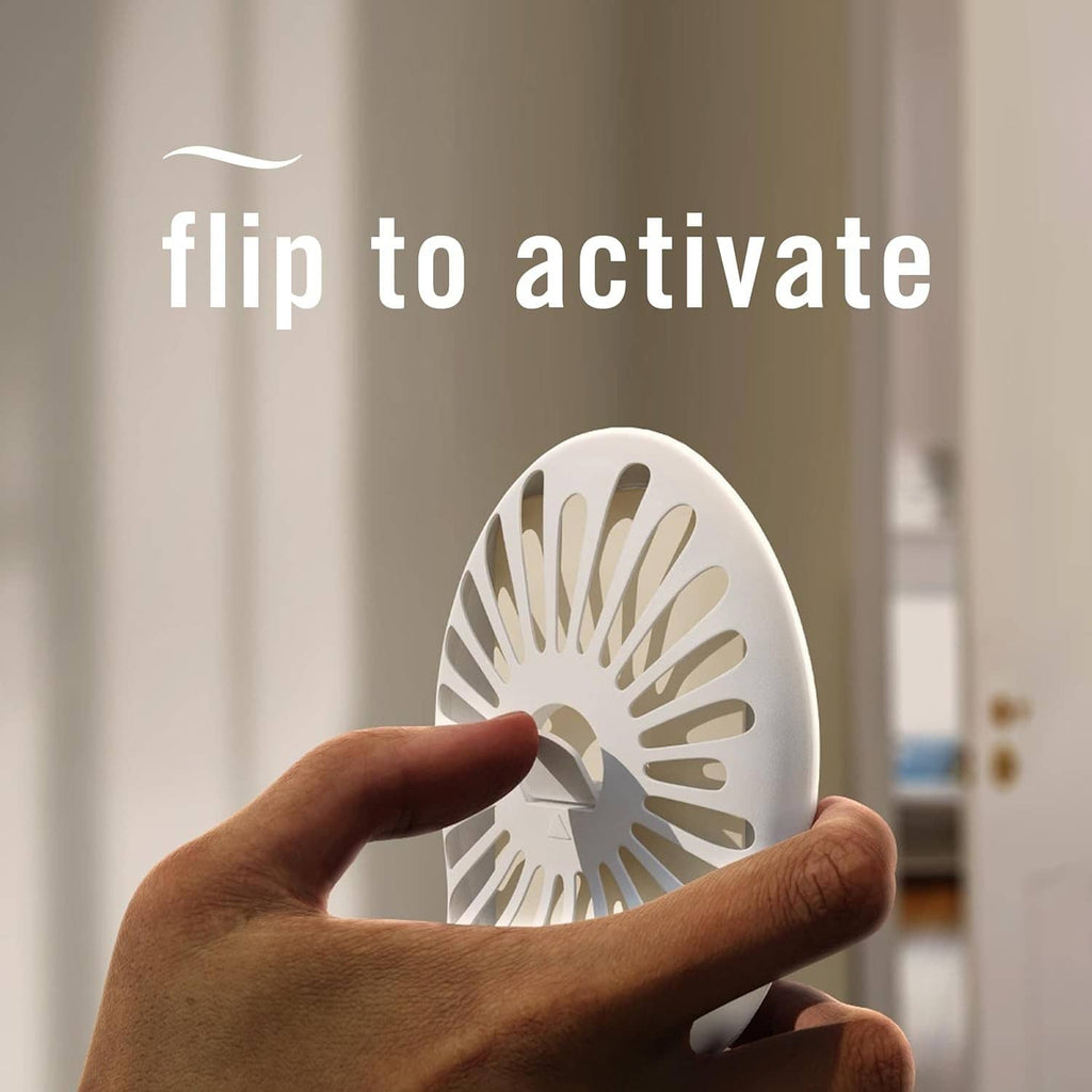 Plug-in air freshener device being flipped to activate, with round scent window