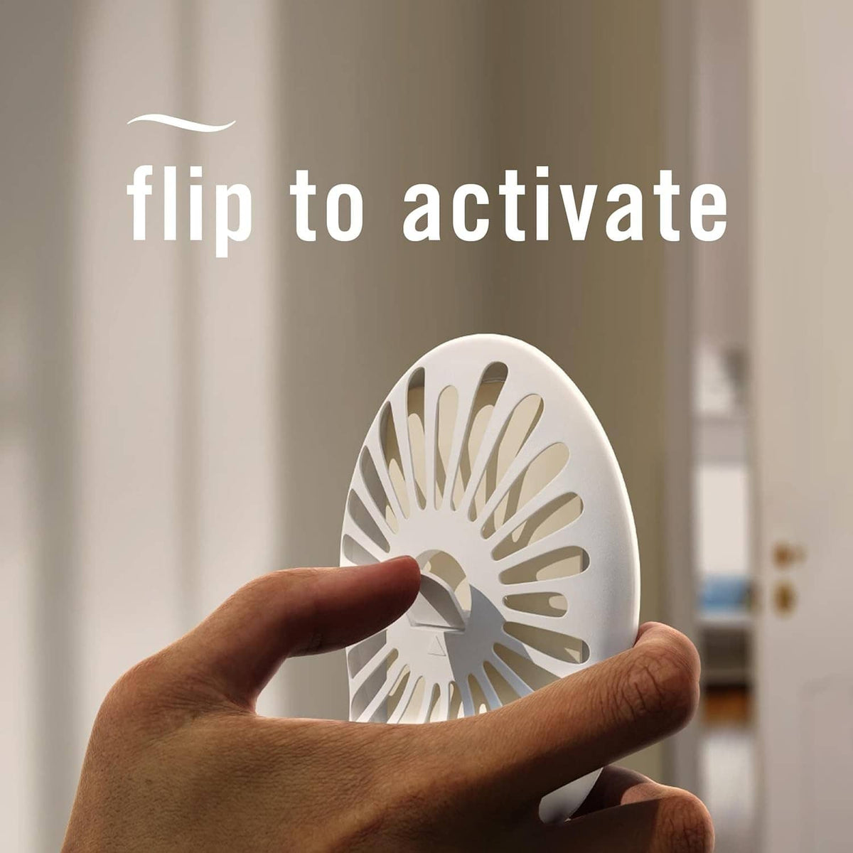 Plug-in air freshener device being flipped to activate, with round scent window