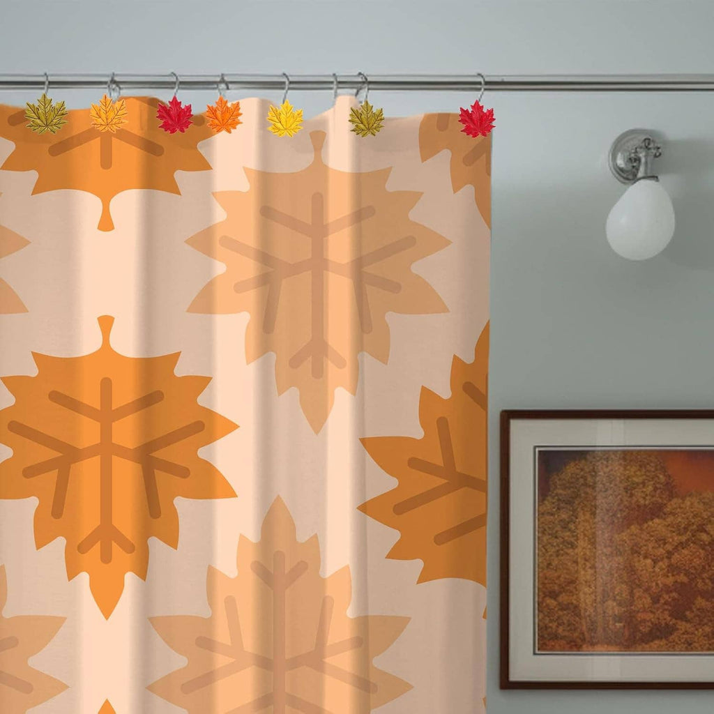 Autumn leaf shower curtain hooks on a patterned curtain; chrome hangers with small leaf accents