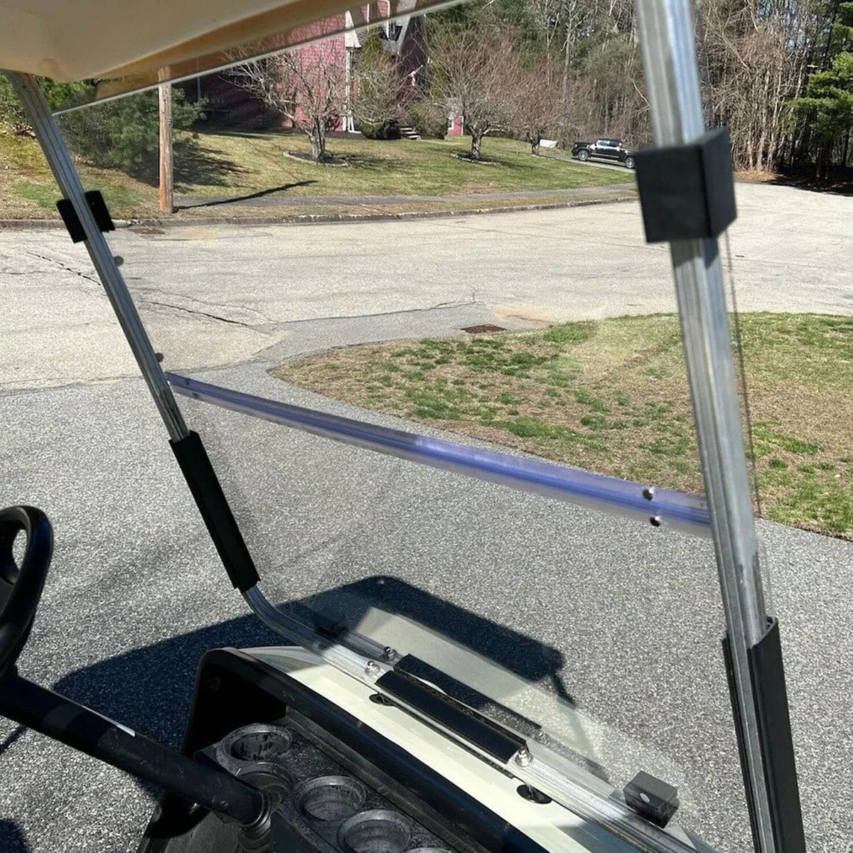 Clear windshield panel with metal rails and black bracket mounts for golf cart