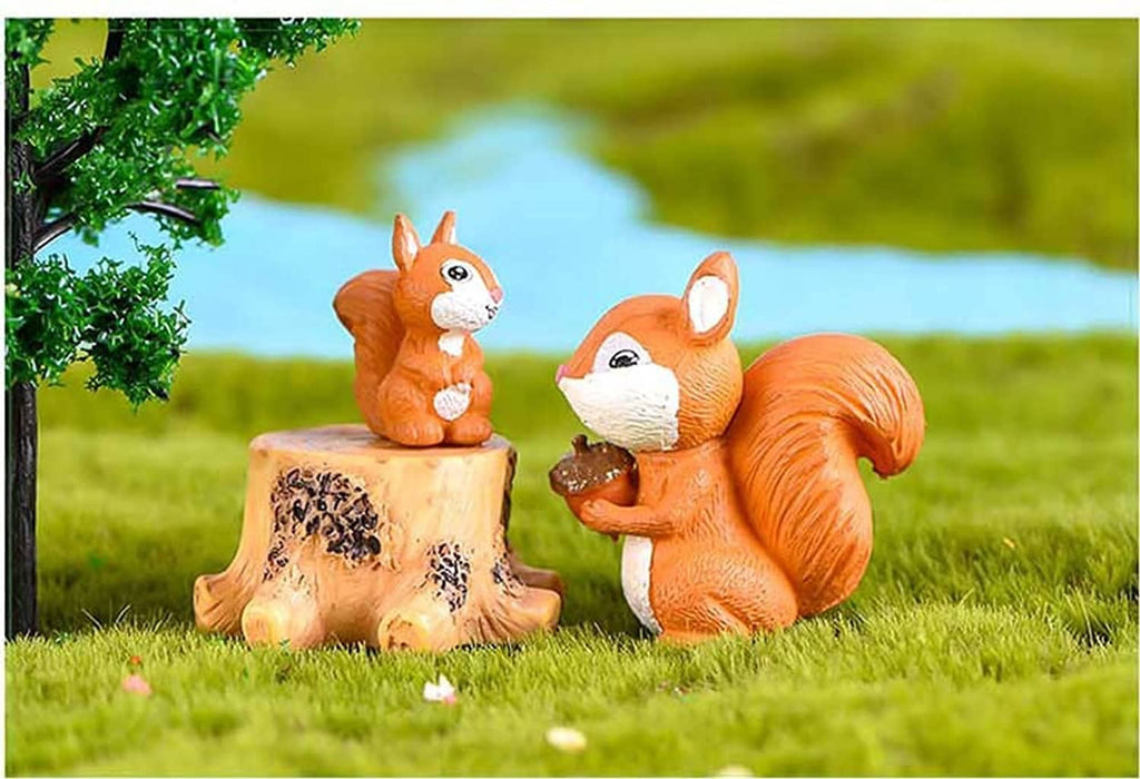 Miniature squirrel figurines, orange and white, perched beside a cut tree stump