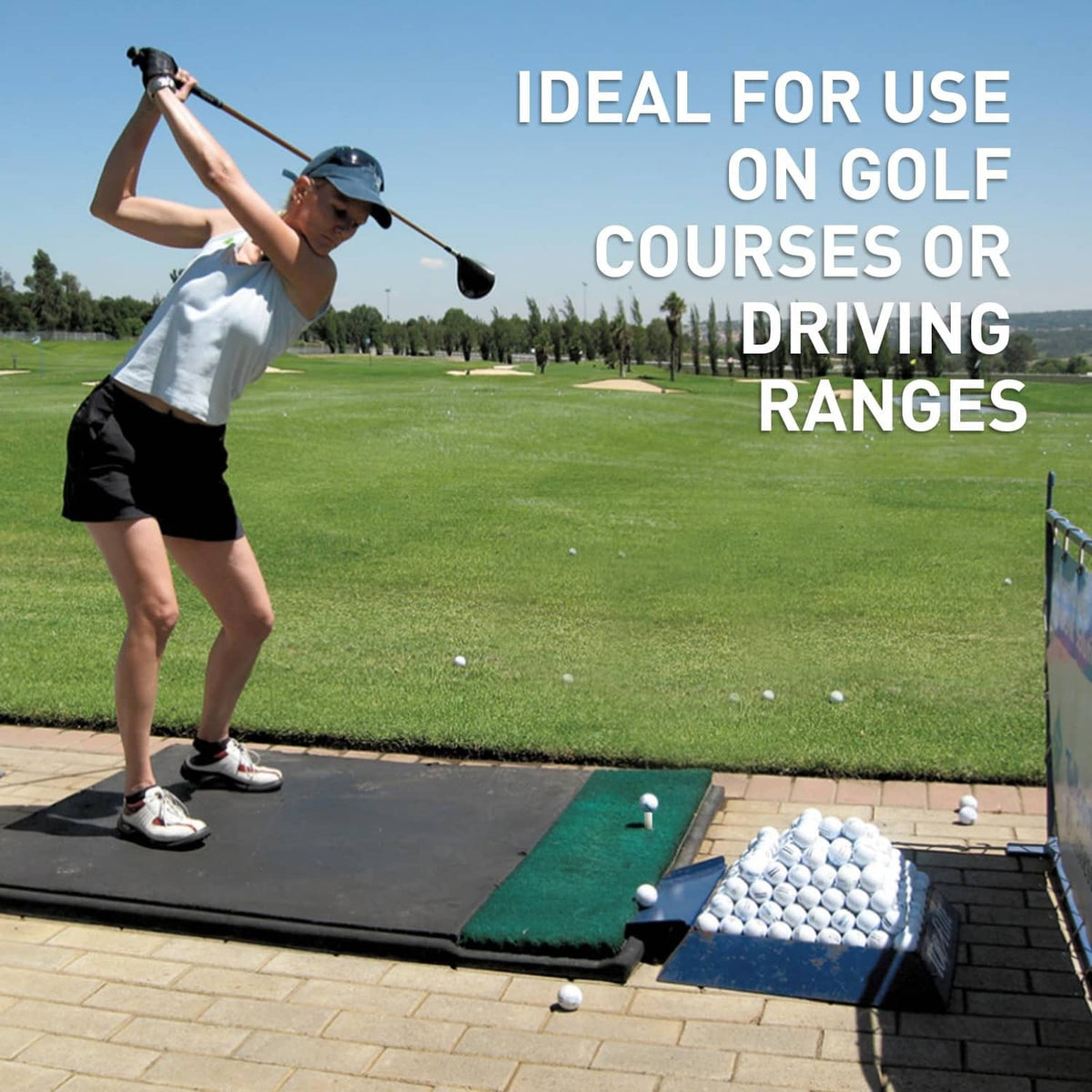 White rubber golf tee standing on a green driving-range practice mat