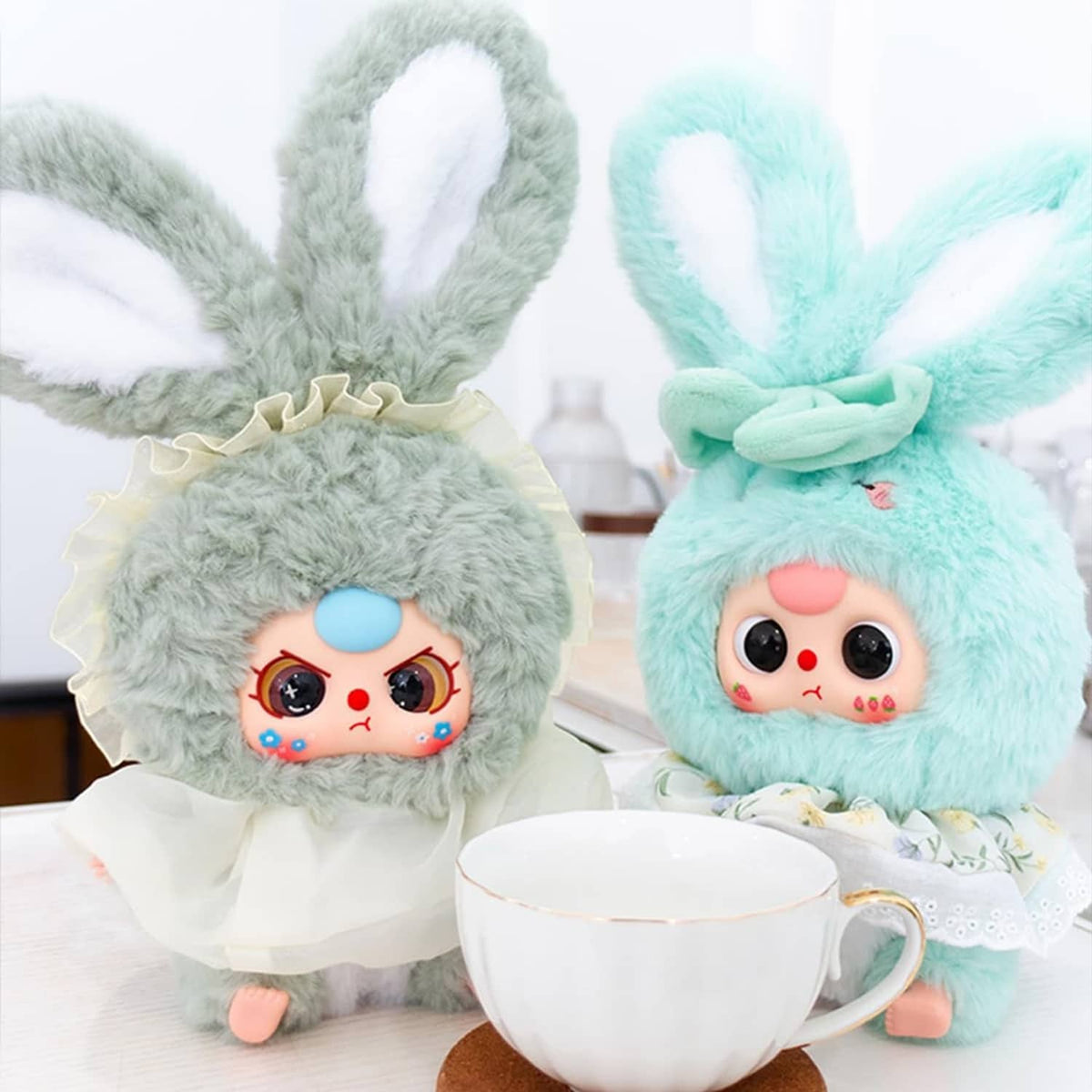 Gray and mint rabbit plush figures in ruffled outfits with cute faces