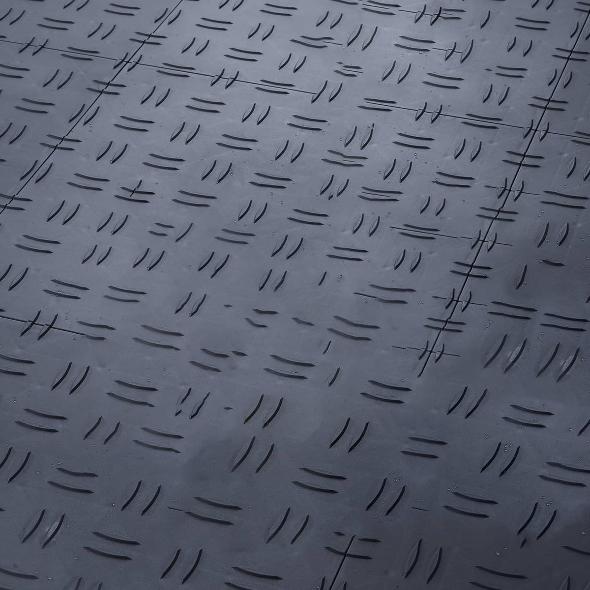 Dark gray garage floor interlocking tiles with raised studded texture and grooves