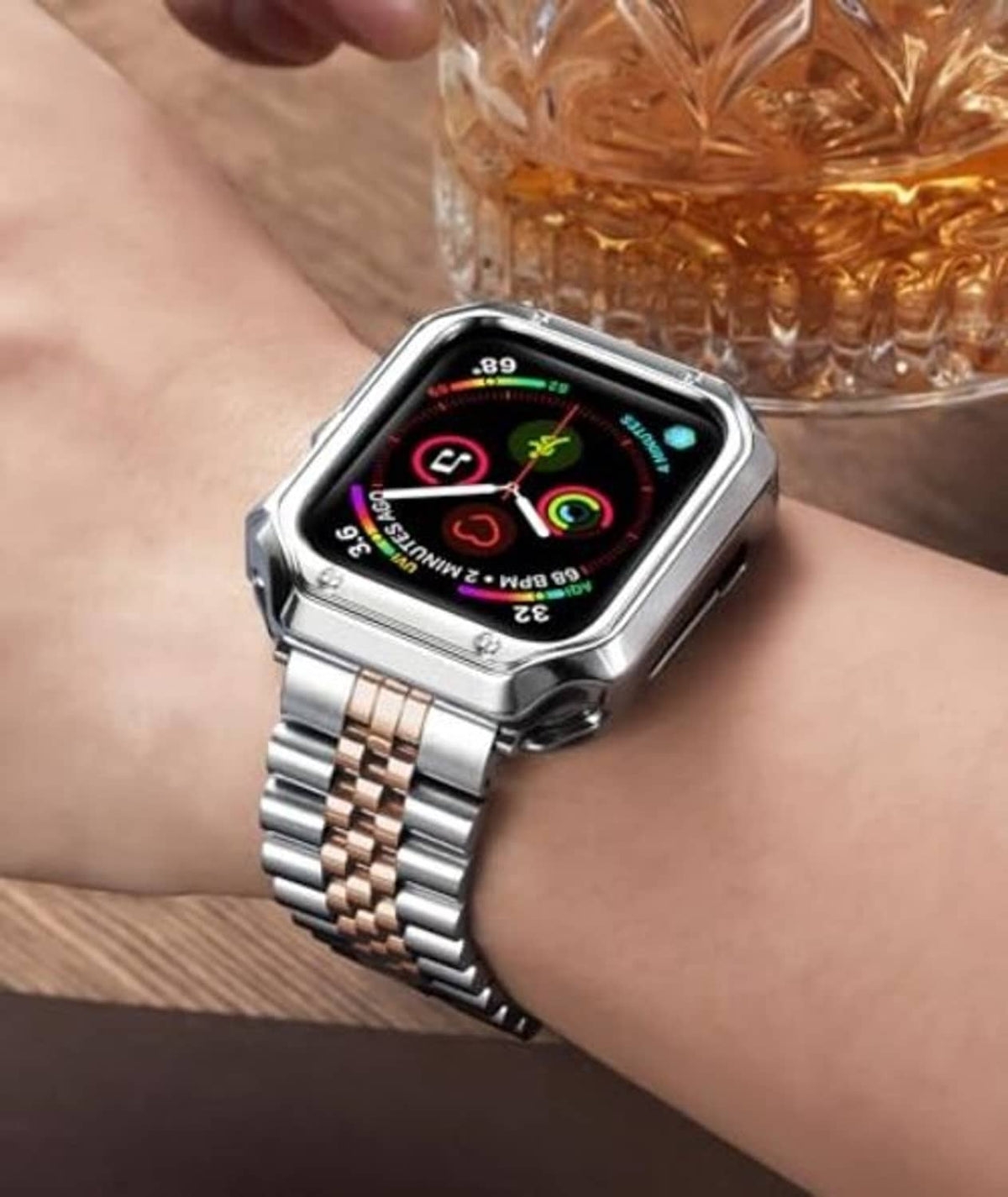 Silver and rose-gold metal link watch band on Apple Watch on wrist